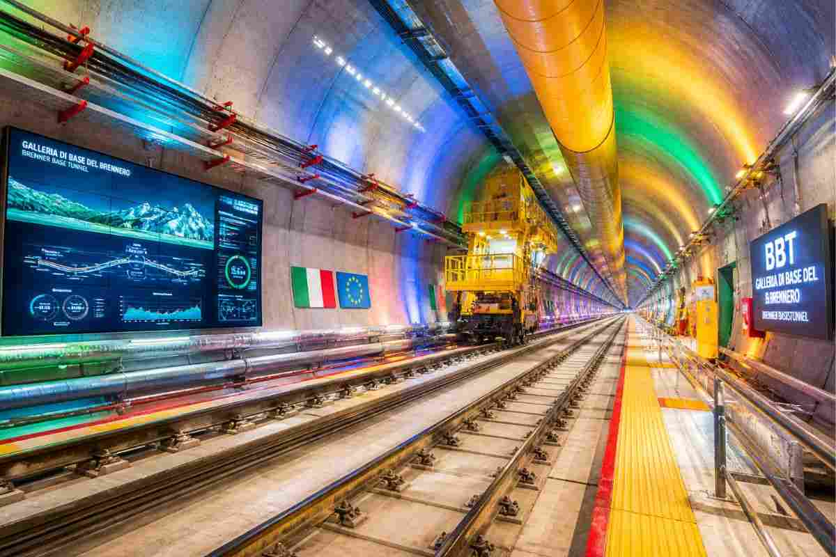 nterno della Galleria di Base del Brennero con illuminazione colorata e sistemi tecnologici avanzati lungo i binari ferroviari sotterranei
