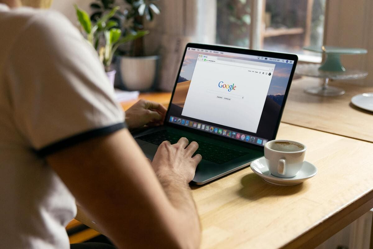 Persona davanti ad un laptop mentre visualizza lo schermo. Il pc è aperto sulla pagina di ricerca di Google